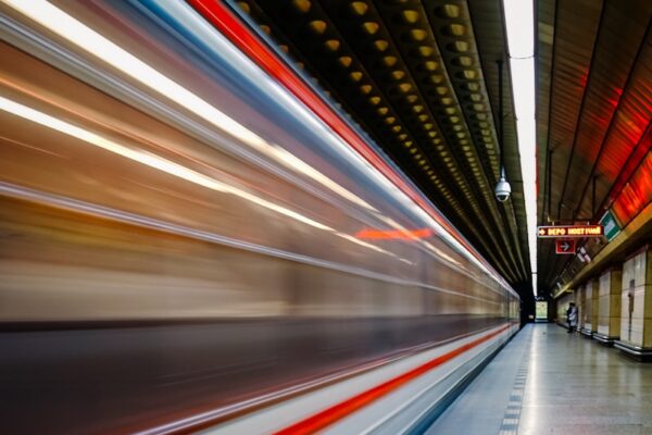 A speeding train streaks through a subway station.